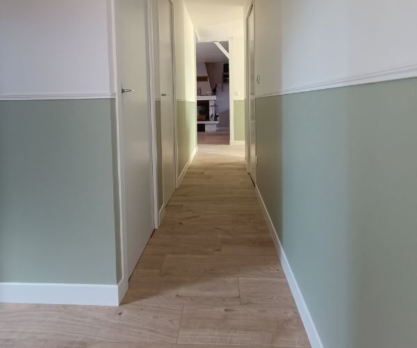 Couloir rénové avec soubassement vert sauge et murs blancs cassés