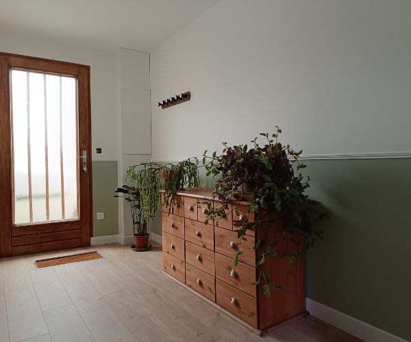 Entrée lumineuse avec peinture bicolore vert sauge et mobilier bois