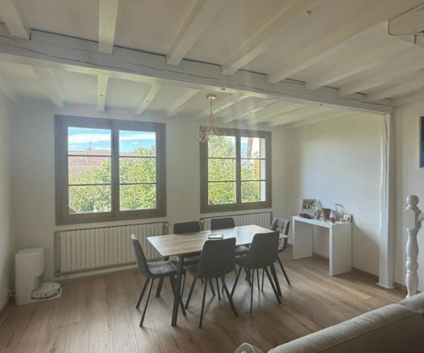 Salle à manger rénovée avec poutres blanches et parquet stratifié à Beaune