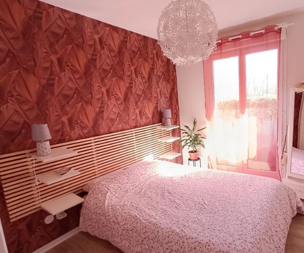 Chambre rénovée avec pose de papier peint décoratif rouge à motifs feuillage