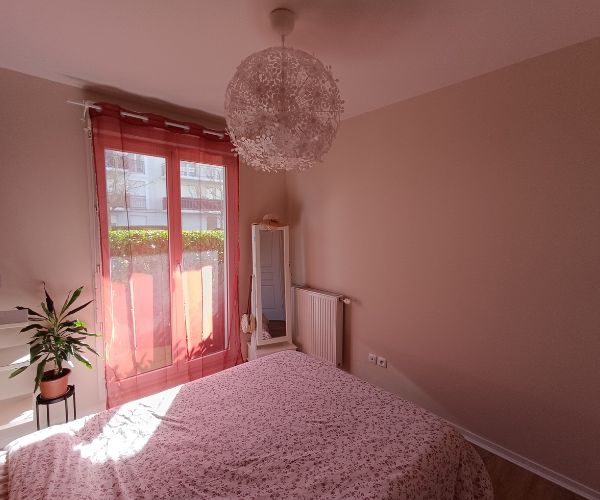 Chambre rénovée avec murs clairs et décoration sobre