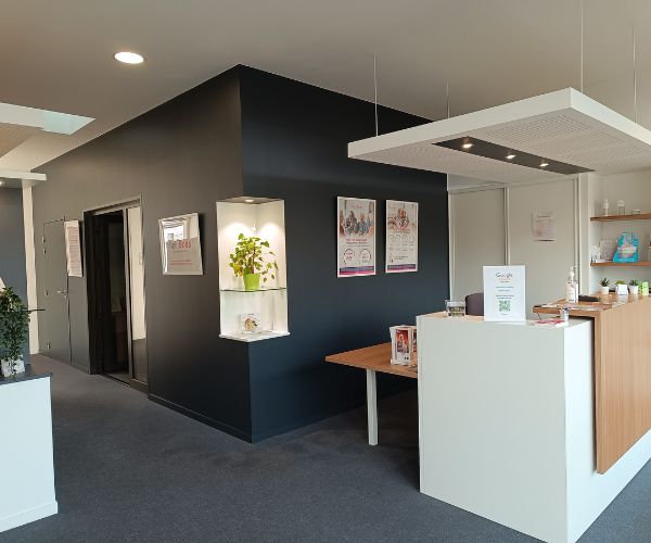 Accueil d’un cabinet audioprothésiste rénové avec peinture murale noire et blanche à Beaune