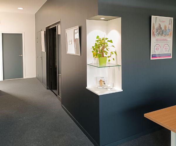 Couloir peint en noir et blanc avec niche décorative dans un cabinet audioprothésiste à Beaune