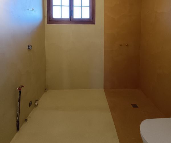 Salle de bain rénovée en béton ciré beige avec douche italienne et murs enduits à Dijon